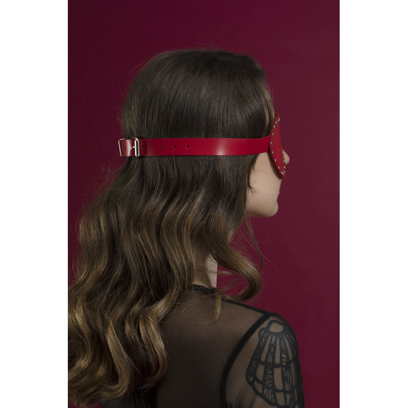 Детальний вигляд збоку червоної маски Feral Feelings Blindfold Mask, що демонструє текстуру натуральної шкіри та заклепки