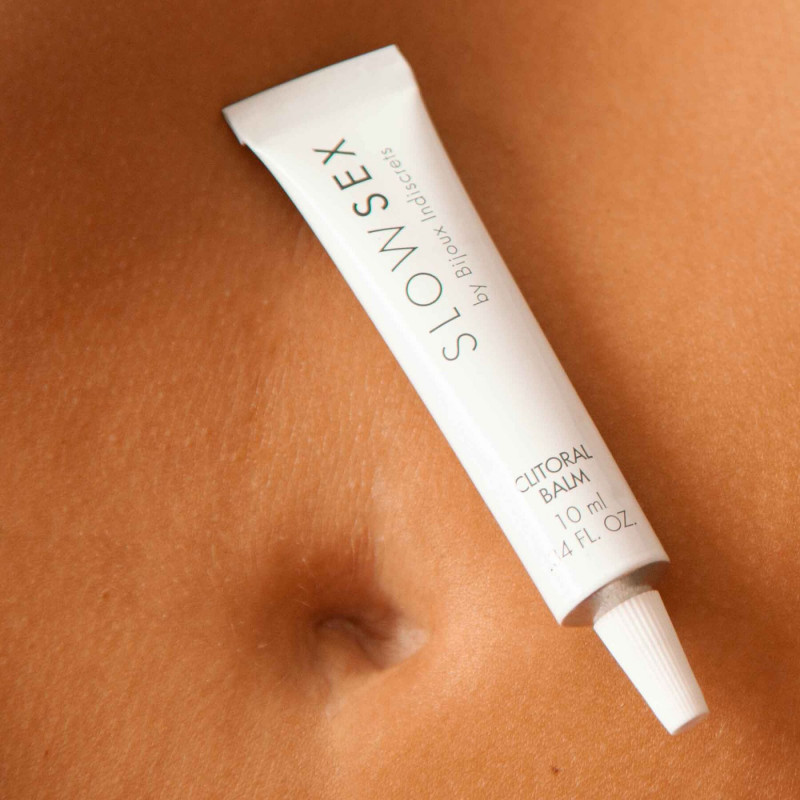 Флакон розігрівального бальзаму Bijoux Indiscrets Slow Sex біля його косметичної упаковки